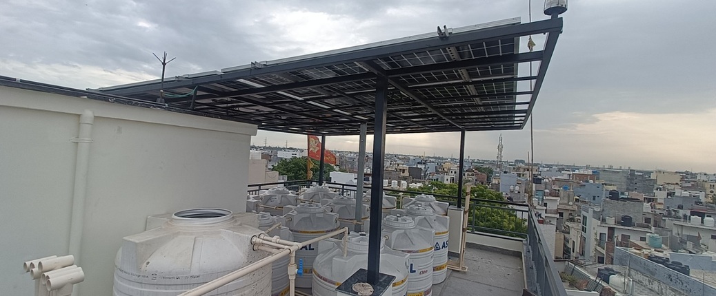 Completed rooftop solar installation raised above water tanks on a terrace